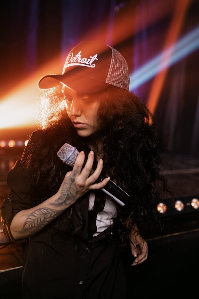 A Woman Wearing a Hat Holding a Microphone